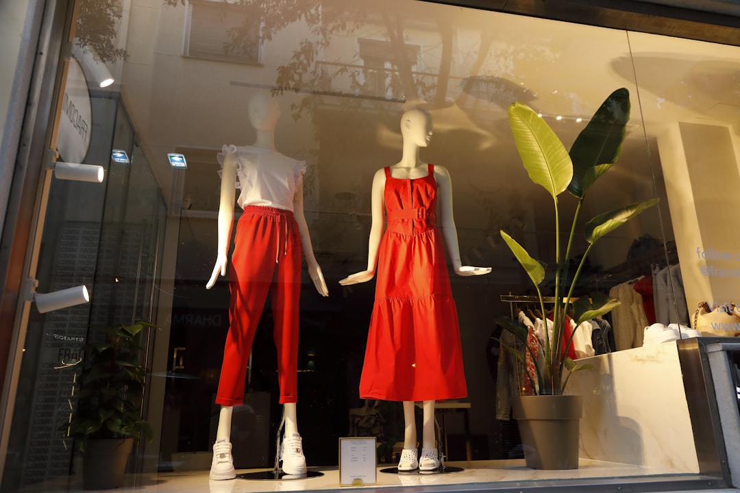 Stylish red outfits display for women’s fashion in boutique window.